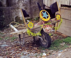 A wheel-barrow somebody went to some trouble to decorate with home-made ornaments.