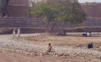 What these men are doing (& there were 100's lining the road) is: making gravel from rocks, using hammers.