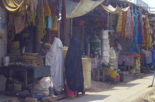 This market, beside the railroad tracks in Peshawar, is selling metallic streamers that look like Christmas tree tinsle but are in-fact for decorating the graves of recently deceased (I suppose flowers are too few & shrivel too fast in the blazing sun...?). The same stall sells garlands of decoratively arranged small notes (typically, 20 rupee bills) which are placed around the necks of the recently returned, the bridegroom at a wedding or a man celebrating the opening of a new business & suchlike.