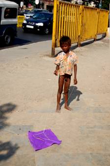 little boy with the type of paper kite children duel with from adjacent roofs.