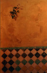 A vine breaks through an old wall with faux tiles in the Andaluz style. The arches above the stairs are from a balcony of the Alhambra but look out on an imaginary desert