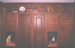 One of two walls with an entirely hand-painted faux bois mural (designed to match the genuine hardwood doors) with trompe l'oeil painted niches for the client's prize Pit Bulls