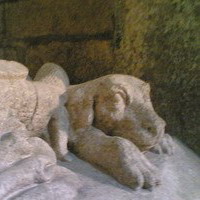 Dog at his master's feet on a stone sarcophagus